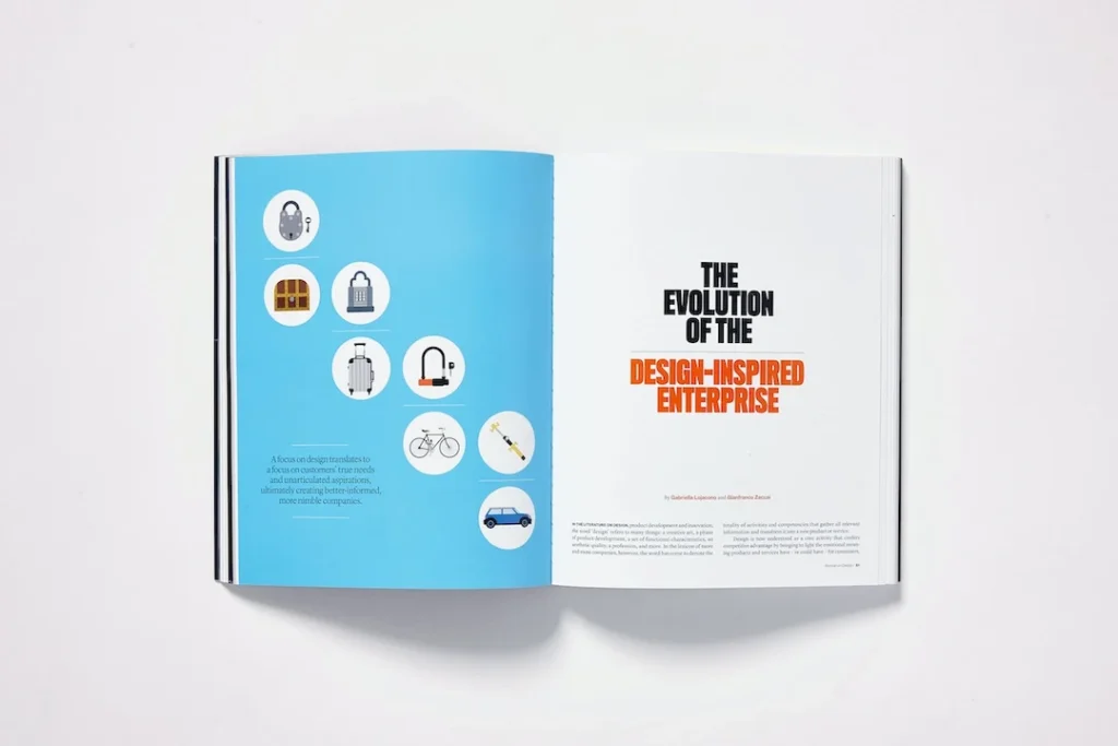 Open magazine spread featuring a design article The left page has a circular icons of various products. The right page shows the article title in bold black and orange typography on a white background, titled "Design for humans"