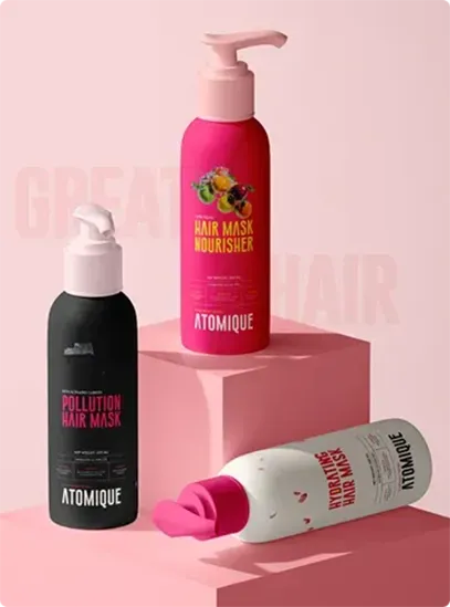 Stylishly displayed Atomique haircare bottles in pink, black, and white variants—showcasing distinct packaging for Pollution Hair Mask, Hair Mask Nourisher, and Hydrating Hair Mask.
