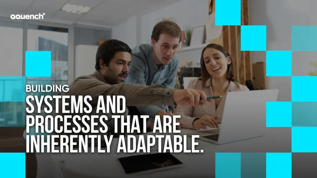 Three designers collaborating at a desk with a laptop, overlaid with the text “Building systems and processes that are inherently adaptable.” Blue square design elements accent the image. Ideal for UX design agencies focused on intuitive and functional UI.